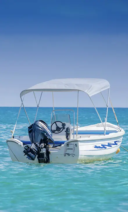 A small, white motorboat in the sea and in the background the sky and the ocean meet