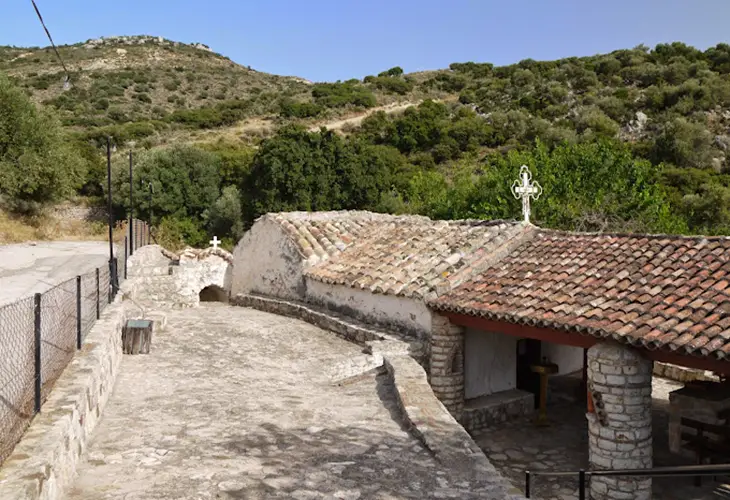 The Moni Sotiros in Tolo is a small, old, stone church surrounded by green hillsides