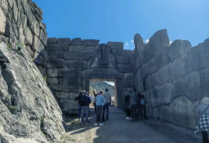 People gathered in front and taking picture of the famous Lion Gate in ancient Mycenae