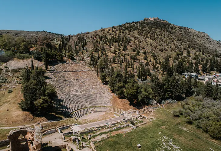 Aerial photo of Argos ancient theatre, ruins of the roman baths and the Larissa Castle on the hill above the town further in the back