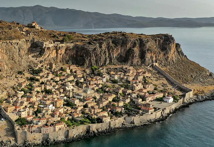 A small town on one side a rock, surrounded by walls and facing the sea